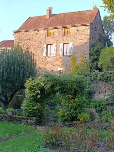 a large brick house with a garden in front of it at Le retour aux sources in Nolay