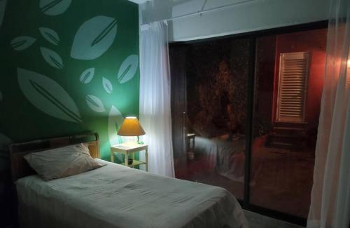 a bedroom with a bed and a green wall at residencia Casa del Roble 2 in Cuernavaca