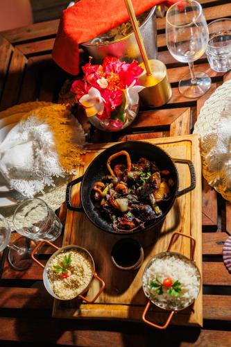 a table with a pan of food on a wooden tray at Almareia Boutique Hotel in Praia dos Carneiros