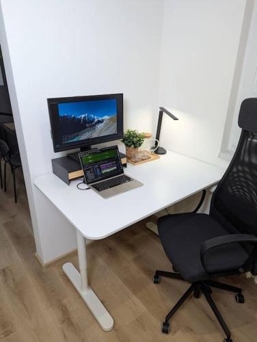 a white desk with a laptop and a computer monitor at Cool Apartment in Znojmo