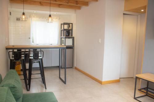 a kitchen with a table and a counter top at Apart Hotel Jardín in El Calafate