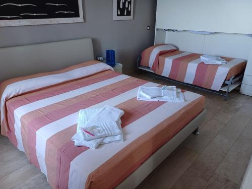two beds in a hotel room with towels on them at la Chiglia in Riomaggiore