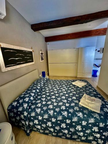 a bedroom with a bed with a black and white comforter at la Chiglia in Riomaggiore