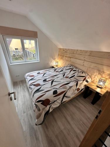 una camera da letto con un letto, una scrivania e una finestra di Les grumeaux Colmar Est a Horbourg