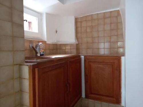 a kitchen with wooden cabinets and a window at Appartement St Jacques in Saint-Gervais-sur-Mare