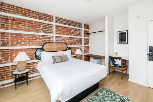 a bedroom with a brick wall and a bed at The Brick Boutique Hotel in Oceanside