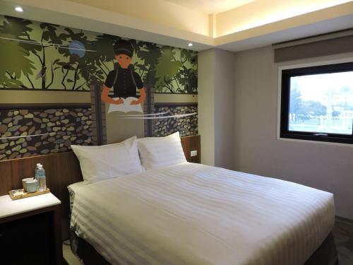 a bedroom with a large bed with a painting on the wall at Meci Hotel in Hualien City