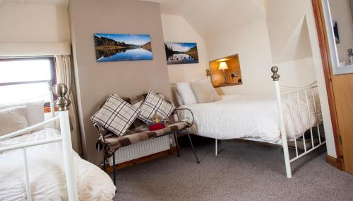 Un dormitorio con 2 camas y una silla. en Kettle House B&B, en Fort Augustus