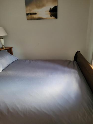 a white bed in a bedroom with a picture on the wall at 75 Park Prewett ROOM 2 in Basingstoke