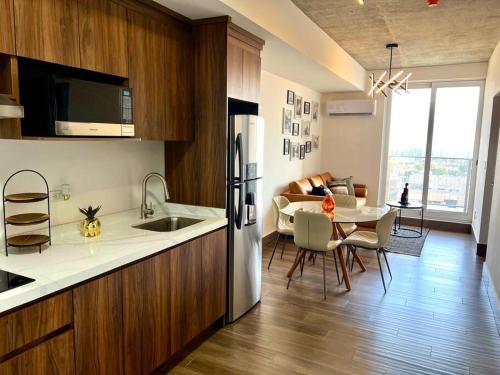 a kitchen with a refrigerator and a table with chairs at Depa con alberca y jardín a 5 min de San Pedro in Monterrey