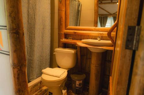 a bathroom with a toilet and a sink at Finca Las Palmas Ecolodge in Puyo