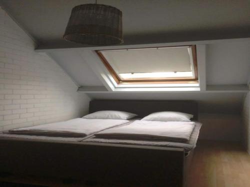 una cama en una habitación con ventana en Duinroos Home with Terrace, en Breskens