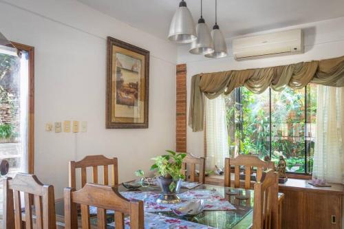 a dining room with a glass table and chairs at Casa Eva, rústica y cálida familiar in Asuncion