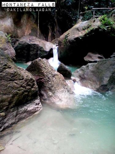 a waterfall in a river with rocks in the water at MLK Bamboo Beachhouse in Alegria