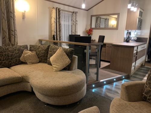 a living room with a couch and a kitchen at luxury 2 bed lodge sleeps up to 6, free parking, Wi-Fi, E3 Whitehouse leisure park towyn in Kinmel Bay
