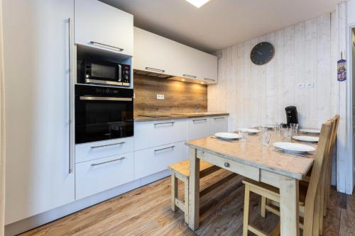 une cuisine avec des armoires blanches et une table en bois dans l'établissement Les Chalets De Bois MÉan - A - Bel appartement rénové sur les Orres 1800 MAE-6581, aux Orres
