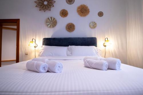 a white bed with three pillows on top of it at Domaine du Rondia - Chambres d'hôtes et Wellness in Wanze