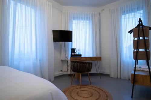 a bedroom with a bed and a desk with a television at Domaine du Rondia - Chambres d'hôtes et Wellness in Wanze