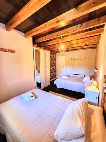 a bedroom with two beds in a room with wooden ceilings at La Esmeralda in Entrambasaguas