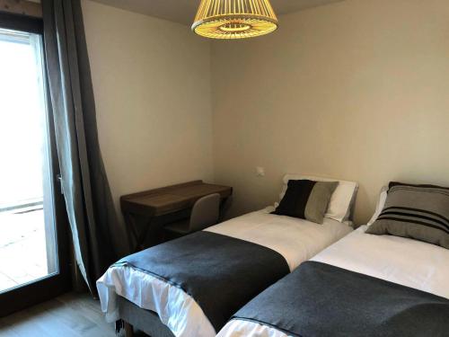 - 2 lits dans une chambre avec une table et une fenêtre dans l'établissement Résidence Le Ridge - RIDGE 307 MAE-7781, à Arc 1600