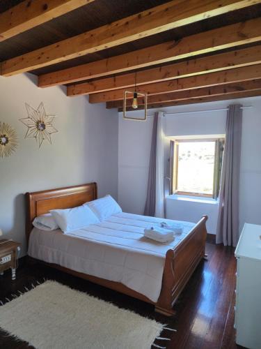 a bedroom with a bed with blue sheets and a window at La Esmeralda in Entrambasaguas