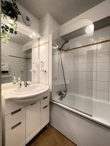 une salle de bain blanche avec une douche et un lavabo dans l'établissement Les Chalets Des Evettes - Appartement six personnes, résidence avec piscine au pied des pistes MAE-1841, à Flumet
