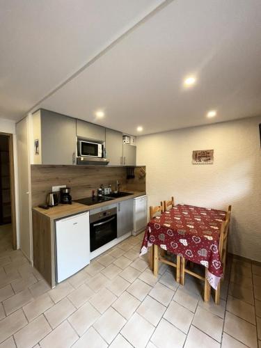 une cuisine avec une table et une cuisine avec une table et des chaises dans l'établissement Résidence Les Bergers - Studio cabine 4 personnes 2 exposé Ouest MAE-7581, à Valloire