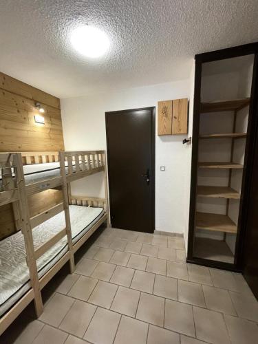 Cette chambre comprend 2 lits superposés et une porte. dans l'établissement Résidence Les Bergers - Studio cabine 4 personnes 2 exposé Ouest MAE-7581, à Valloire