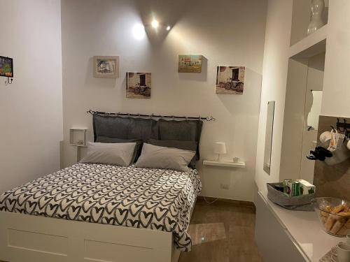 a bedroom with a bed with a black and white comforter at Le Colonne 14 in Bari