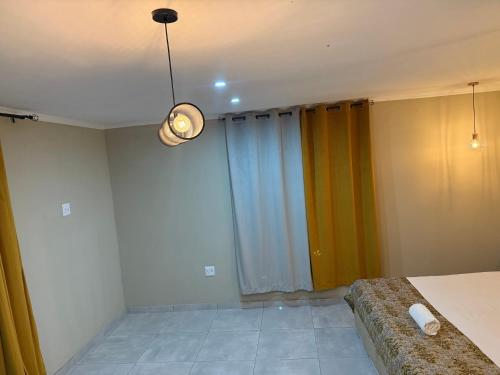 a bedroom with a bed and a light on the ceiling at Horizon Bed and Breakfast in Roodepoort