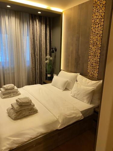 a bedroom with a large white bed with towels on it at Zlatibor Golden Lux Apartment in Zlatibor