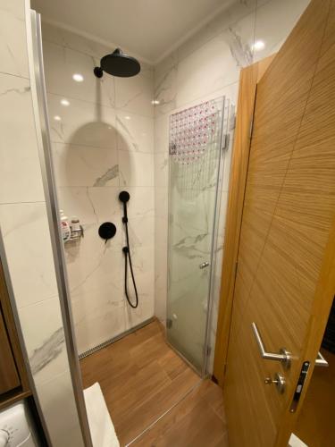 a shower with a glass door in a bathroom at Zlatibor Golden Lux Apartment in Zlatibor
