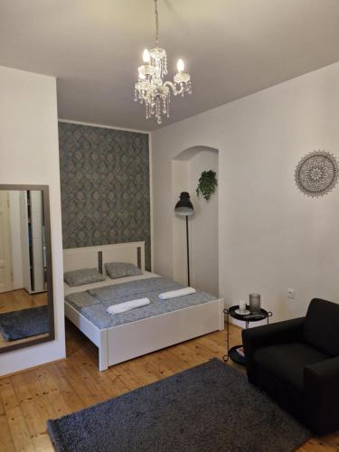 a bedroom with a bed and a couch and a chandelier at Old city life in Maribor