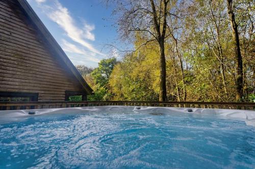 a hot tub in the backyard of a house at Wootton, woodland lodge with hot tub for 8 in Oakamoor