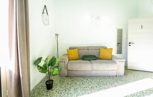a white couch with yellow pillows in a living room at Valguarnera Studio Apartments in Palermo