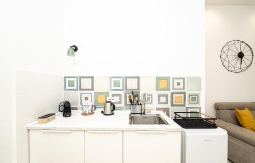 a kitchen with a sink and a couch at Valguarnera Studio Apartments in Palermo