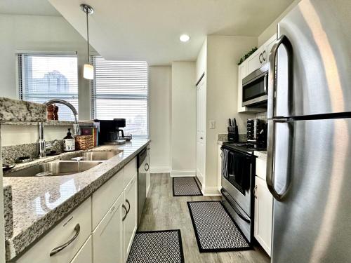 a kitchen with a stainless steel refrigerator and a sink at Amazing New City View Mins To IU Health & Lucas Oil Stadium in Indianapolis