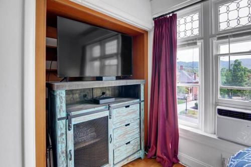 a tv on a dresser in a room with a window at B Street C in Salt Lake City