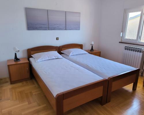 a bedroom with two beds and two windows at Apartmani Suton in Primošten