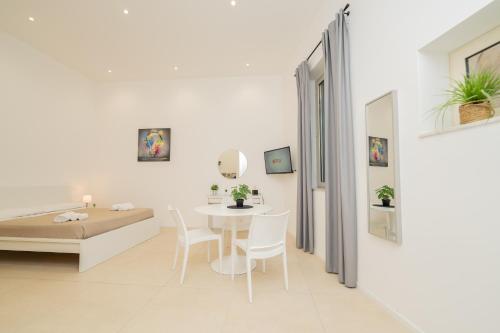 a white living room with a table and chairs at Valguarnera Studio Apartments in Palermo