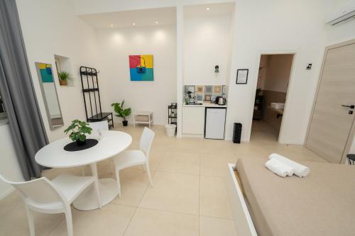 a living room with a white table and chairs at Valguarnera Studio Apartments in Palermo