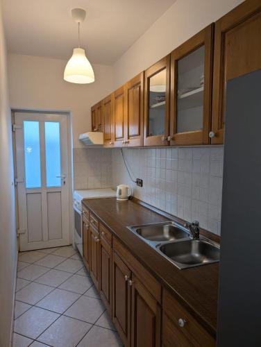 a kitchen with wooden cabinets and a sink at Apartmani Suton in Primošten