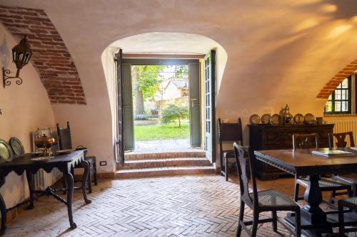 a room with a table and chairs and an open door at Palazzo Sismonda in Corneliano d'Alba