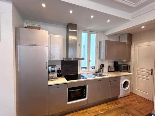 La cuisine est équipée d'un réfrigérateur et d'un évier. dans l'établissement Charmant appartement 45m2 Trocadero, à Paris