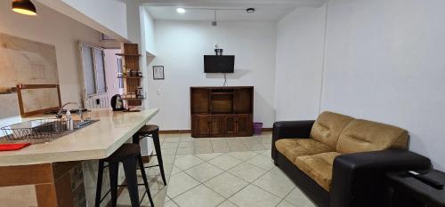 a living room with a couch and a kitchen at Depa Púrpura Caracol in San Antonio de la Cal