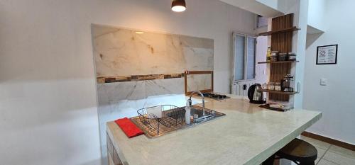 a kitchen with a marble counter top with a sink at Depa Púrpura Caracol in San Antonio de la Cal