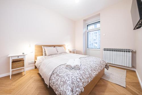 a white bedroom with a large bed and a window at Casa Linda Zagreb - FREE PARKING in Zagreb
