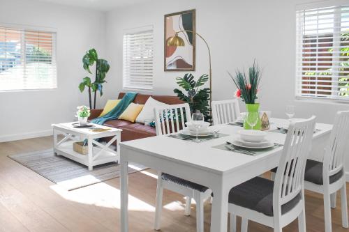 a white dining room with a white table and chairs at Modern 2B1B Near SAP, SJSU, Convention Center in San Jose