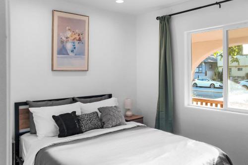 Un dormitorio con una cama blanca con una ventana. en Modern 2B1B Near SAP, SJSU, Convention Center, en San José
