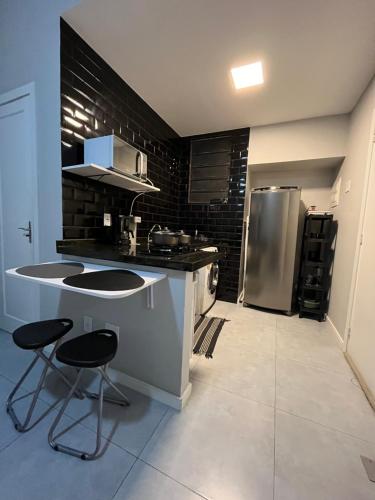 eine Küche mit einer Theke und 2 Hockern in der Unterkunft Loft Icaraí in Niterói
